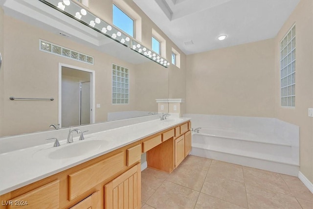 bathroom featuring a bath, double vanity, a sink, and tile patterned flooring