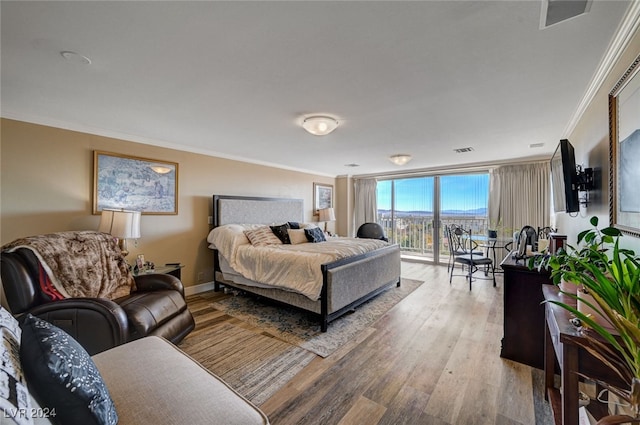 bedroom with access to exterior, crown molding, and wood-type flooring