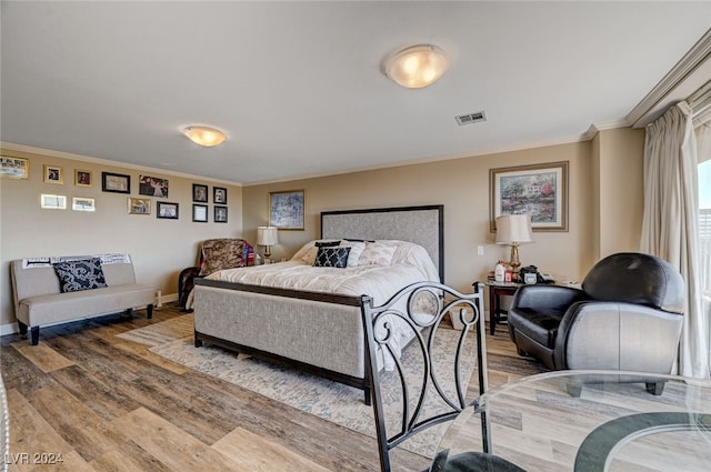 bedroom featuring ornamental molding and hardwood / wood-style flooring