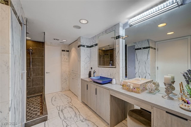 bathroom featuring vanity, a tile shower, and tile walls