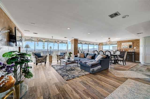 living room featuring a notable chandelier, light hardwood / wood-style floors, and ornamental molding