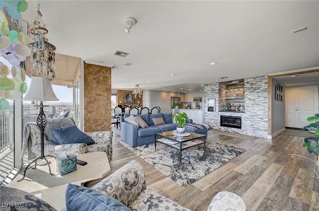 living room with a stone fireplace and light hardwood / wood-style flooring