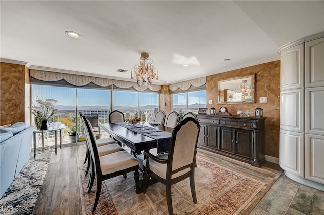 dining area featuring ornamental molding, a chandelier, and light hardwood / wood-style floors