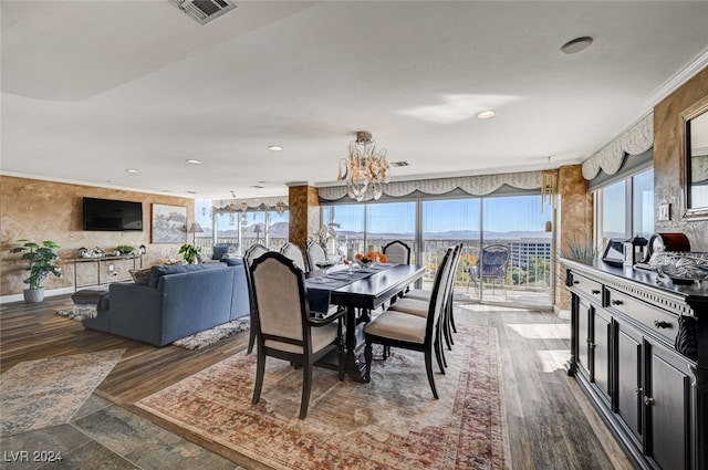 dining room with crown molding, hardwood / wood-style floors, and a notable chandelier