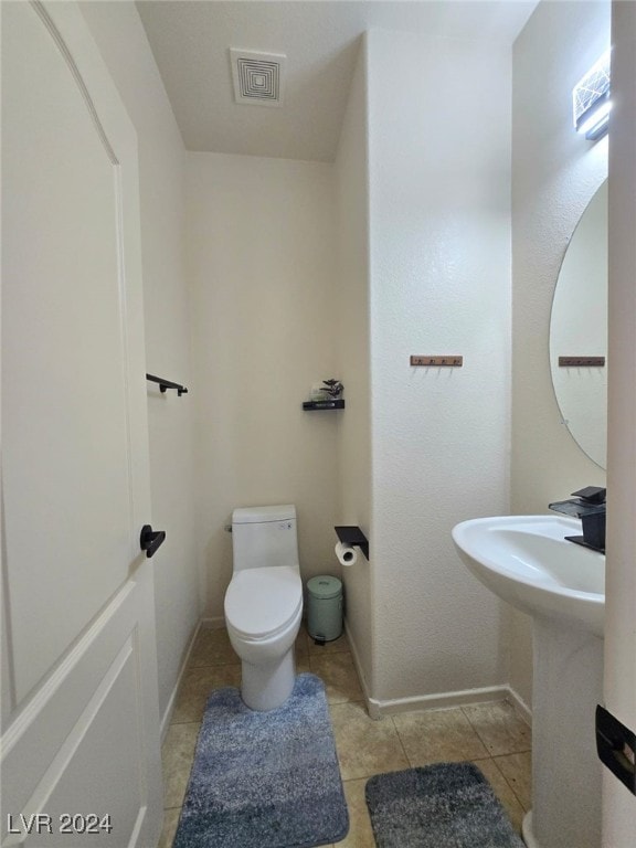 bathroom with toilet and tile patterned floors