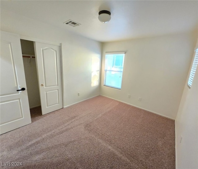 unfurnished bedroom featuring carpet flooring and a closet