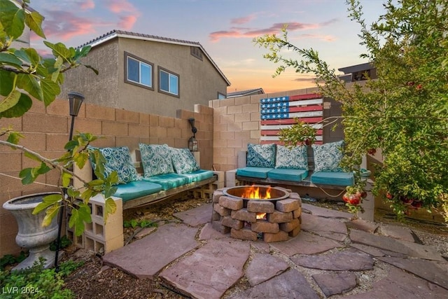 patio terrace at dusk featuring an outdoor living space with a fire pit