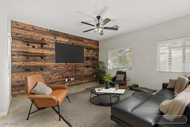 living room featuring ceiling fan, light tile patterned flooring, and wooden walls