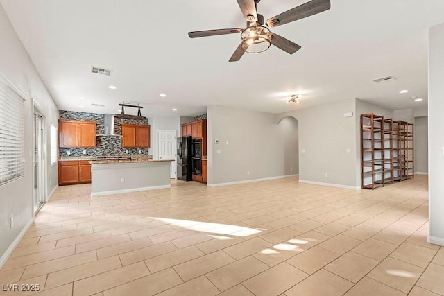 unfurnished living room featuring light tile patterned floors and ceiling fan