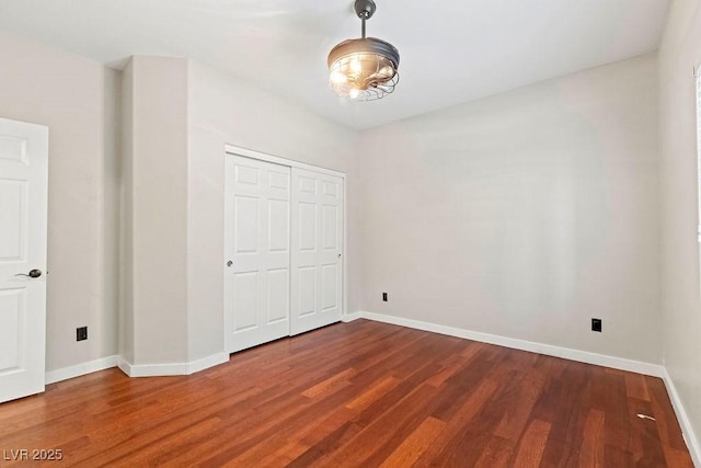 unfurnished bedroom with wood-type flooring and a closet