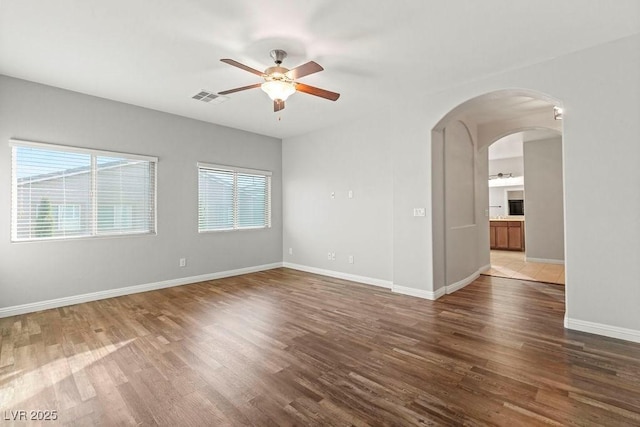 unfurnished room featuring dark wood-type flooring and ceiling fan