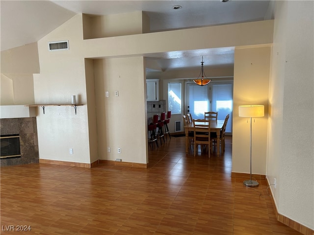 living room with a high end fireplace, hardwood / wood-style floors, and high vaulted ceiling