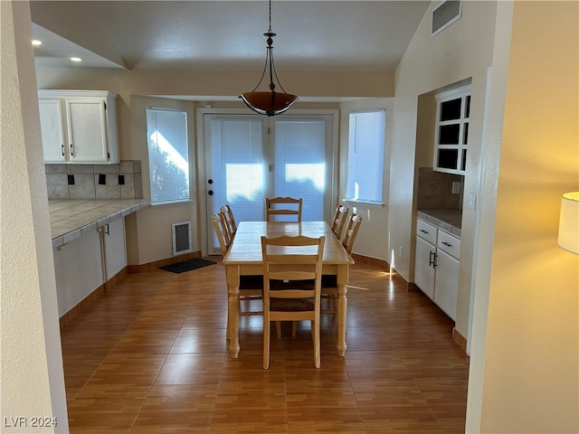 dining space featuring hardwood / wood-style flooring and vaulted ceiling