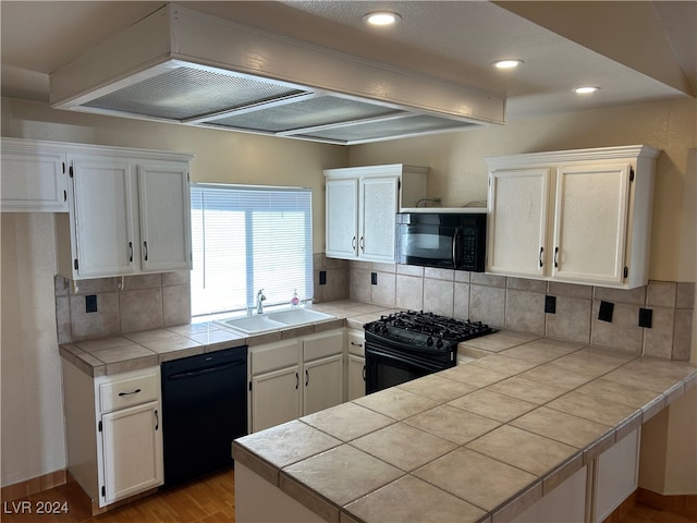 kitchen featuring sink, tile countertops, white cabinetry, and black appliances