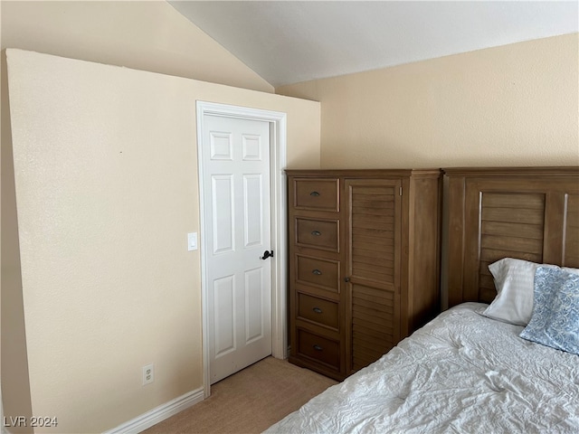 bedroom with light colored carpet and lofted ceiling