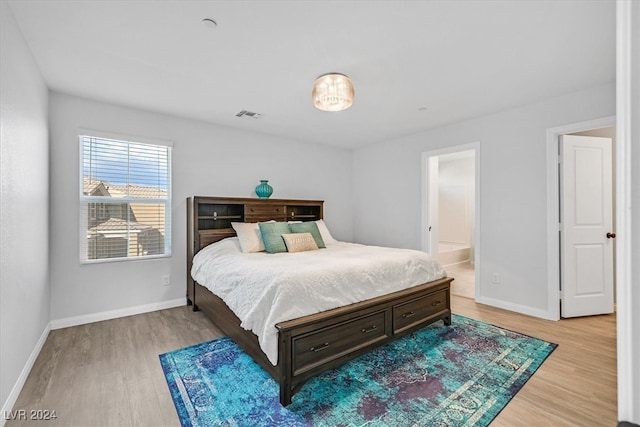 bedroom featuring ensuite bathroom and wood-type flooring