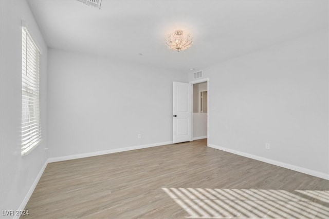 spare room featuring light wood-type flooring and a healthy amount of sunlight