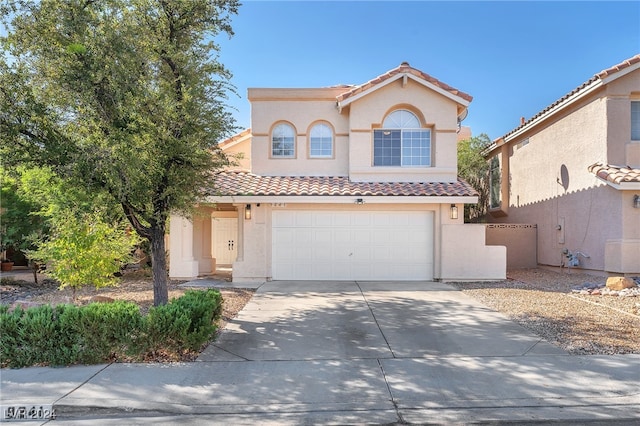 mediterranean / spanish-style home with a garage