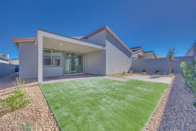 back of house featuring a patio and a lawn