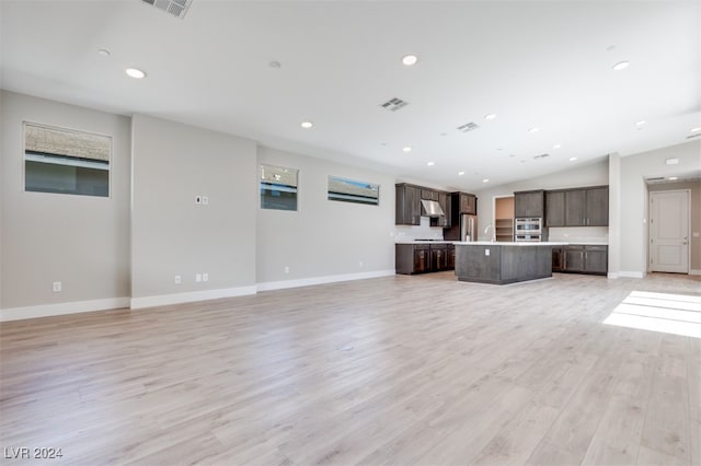 unfurnished living room with lofted ceiling and light wood-type flooring