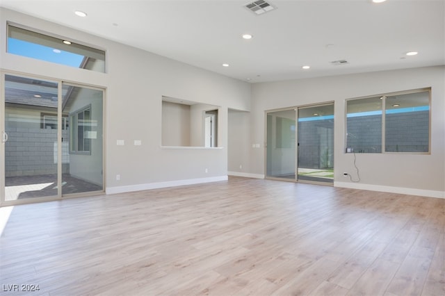 unfurnished room featuring vaulted ceiling and light hardwood / wood-style floors