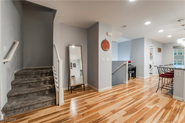 kitchen featuring a breakfast bar, light wood-type flooring, and washer / clothes dryer