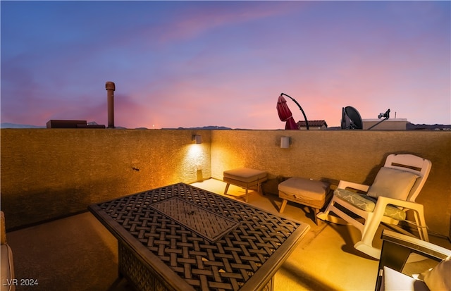 patio terrace at dusk featuring a balcony