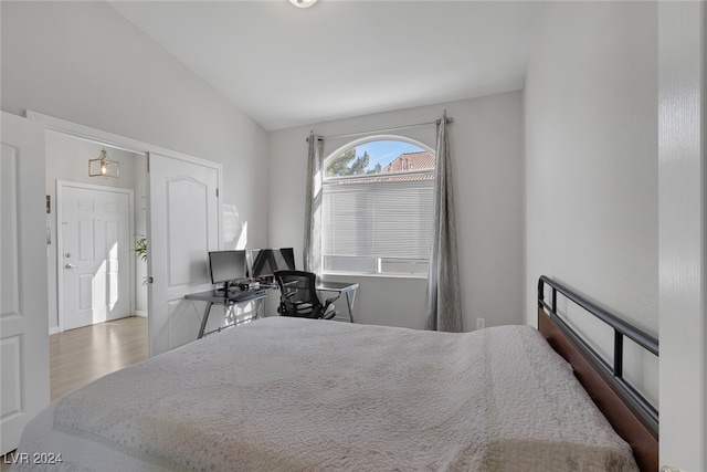 bedroom featuring hardwood / wood-style floors and vaulted ceiling