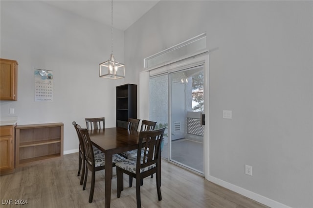 dining room with a notable chandelier, a high ceiling, and light hardwood / wood-style flooring