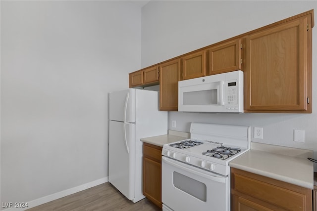 kitchen featuring white appliances and light hardwood / wood-style flooring