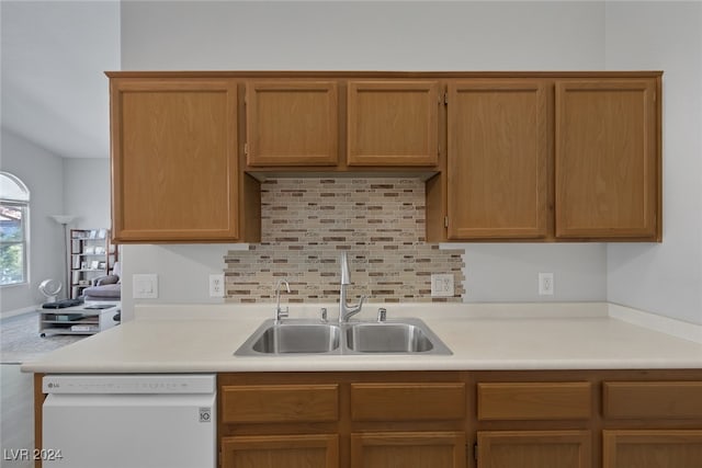 kitchen with dishwasher, sink, and tasteful backsplash