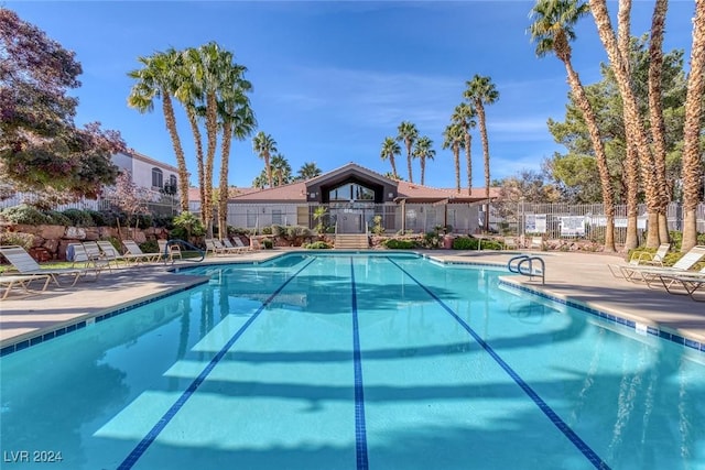 pool with a patio and fence