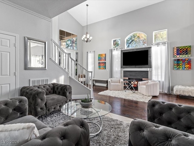 living room with a chandelier, wood-type flooring, and high vaulted ceiling