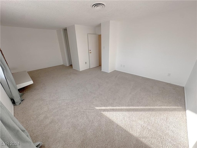 carpeted spare room with a textured ceiling