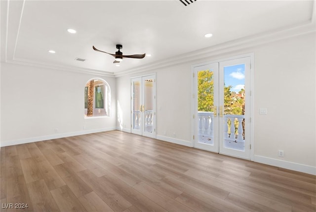 spare room featuring light wood-type flooring, ceiling fan, french doors, and crown molding