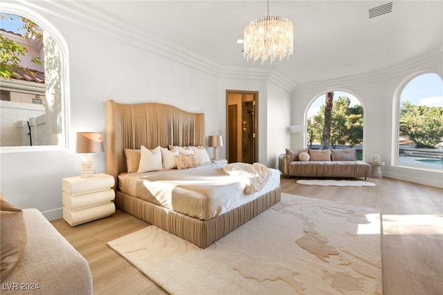 bedroom featuring ornamental molding, a notable chandelier, and light wood-type flooring