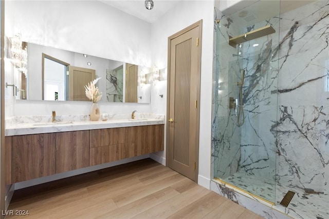 bathroom featuring a tile shower, hardwood / wood-style flooring, and vanity