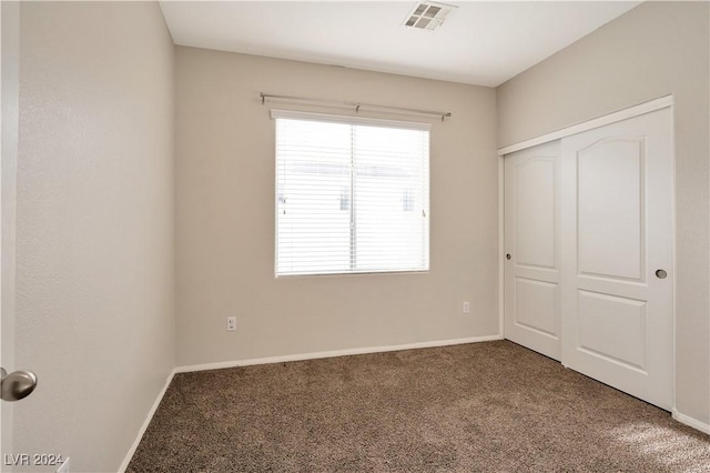 unfurnished bedroom with a closet and carpet