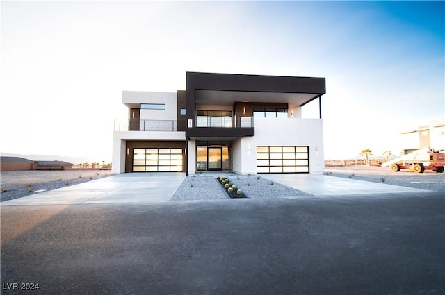 contemporary house featuring concrete driveway, stucco siding, and an attached garage