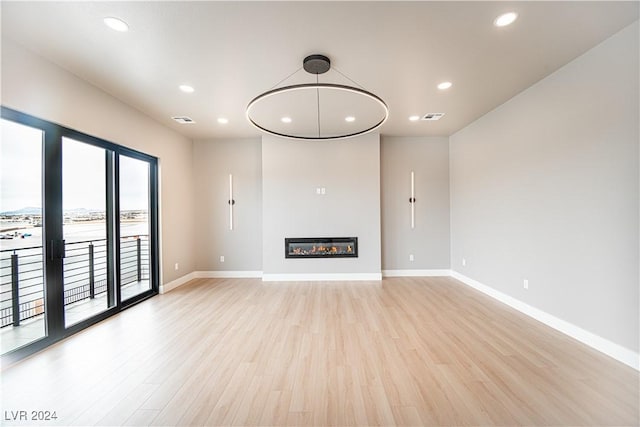 unfurnished living room with baseboards, light wood-style flooring, and visible vents