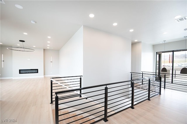corridor with recessed lighting, an upstairs landing, light wood finished floors, and visible vents