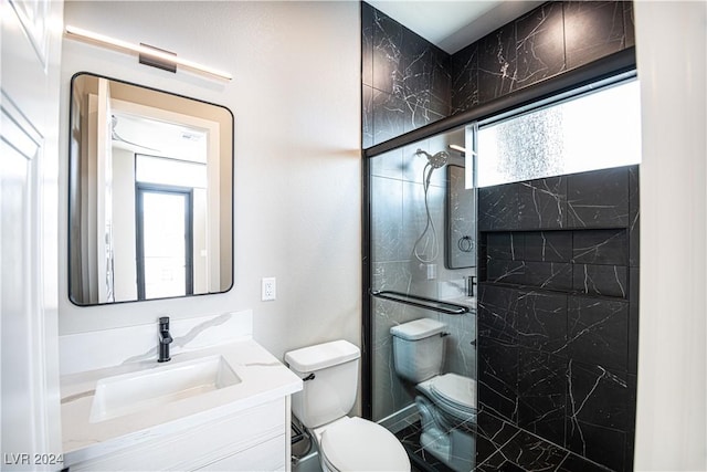 full bathroom featuring toilet, vanity, and a shower stall