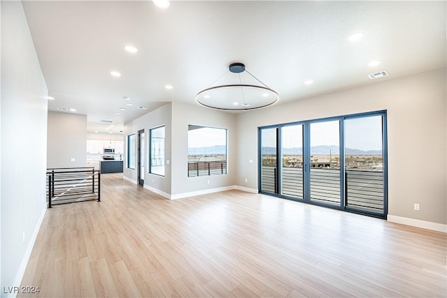 unfurnished living room with baseboards, visible vents, recessed lighting, and light wood finished floors