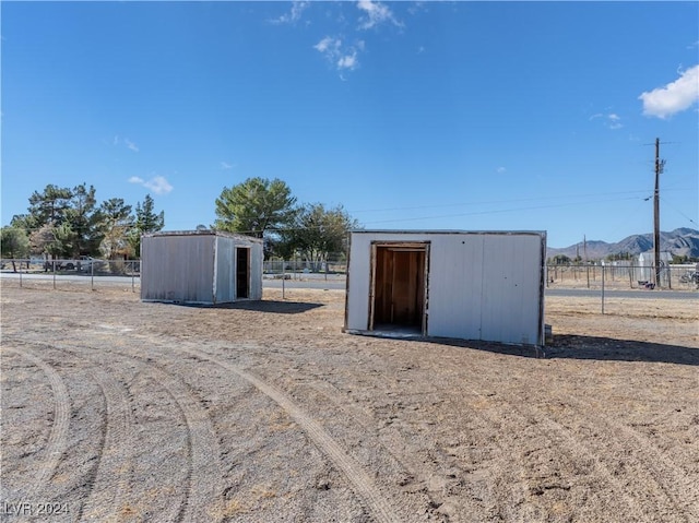 view of outbuilding featuring a rural view and a mountain view