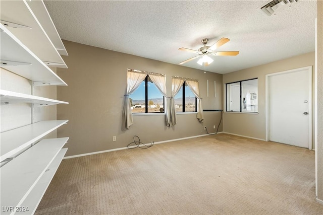 spare room with ceiling fan, carpet floors, and a textured ceiling