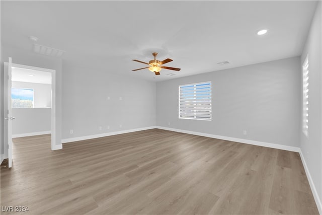 spare room featuring a wealth of natural light, ceiling fan, and light wood-type flooring