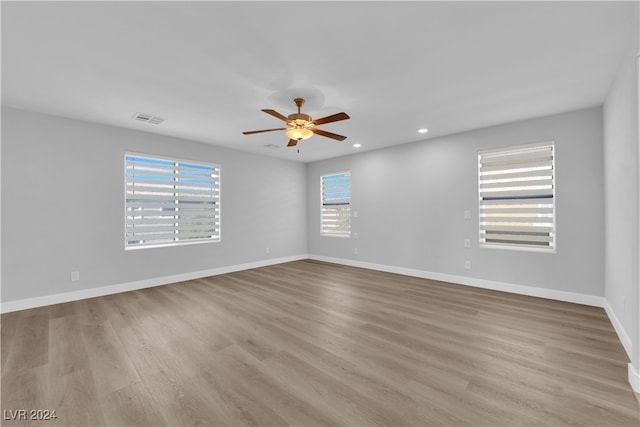 unfurnished room with ceiling fan, a wealth of natural light, and light hardwood / wood-style flooring