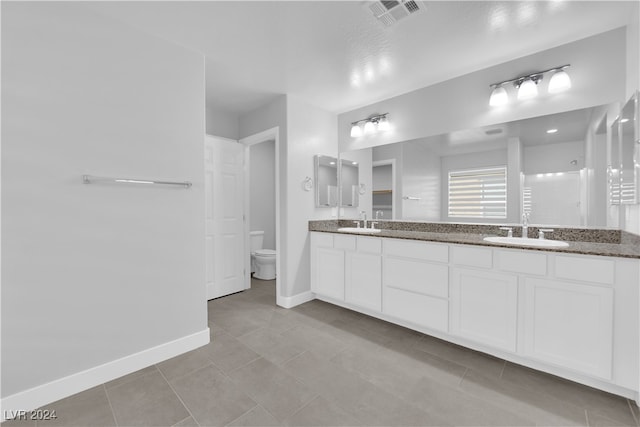 bathroom featuring a shower, tile patterned flooring, vanity, and toilet