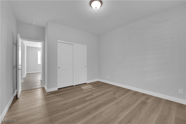 unfurnished bedroom featuring light wood-type flooring and a closet