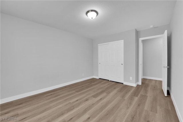 unfurnished bedroom featuring light hardwood / wood-style floors and a closet